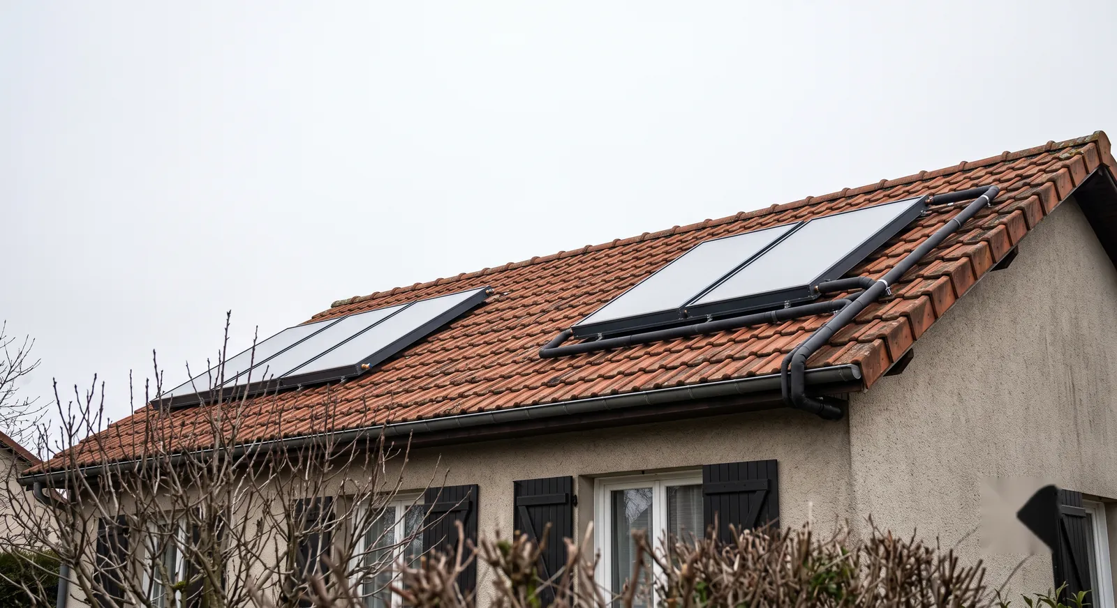 Capteurs solaires thermiques posés en surimposition sur une toiture en tuiles, par ciel couvert